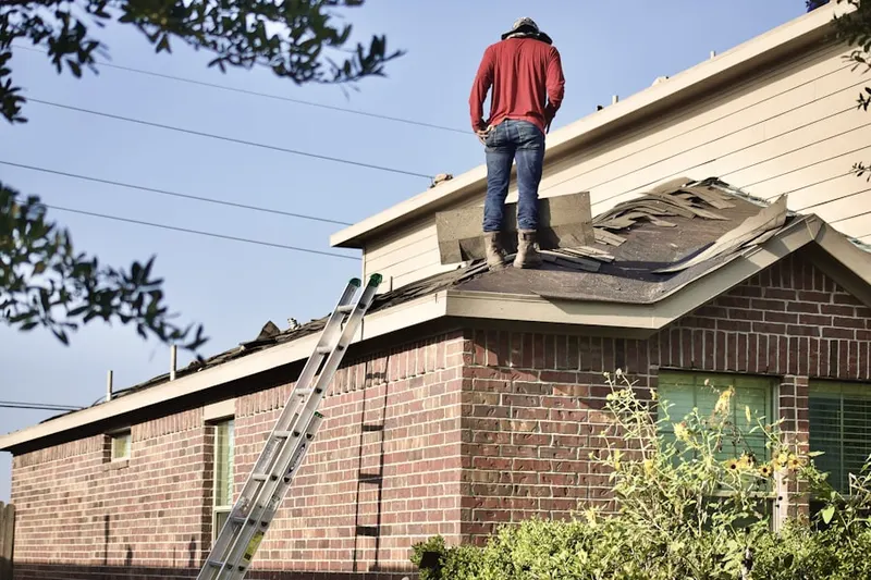 Professional roofer working on a residential roof in Lower Village